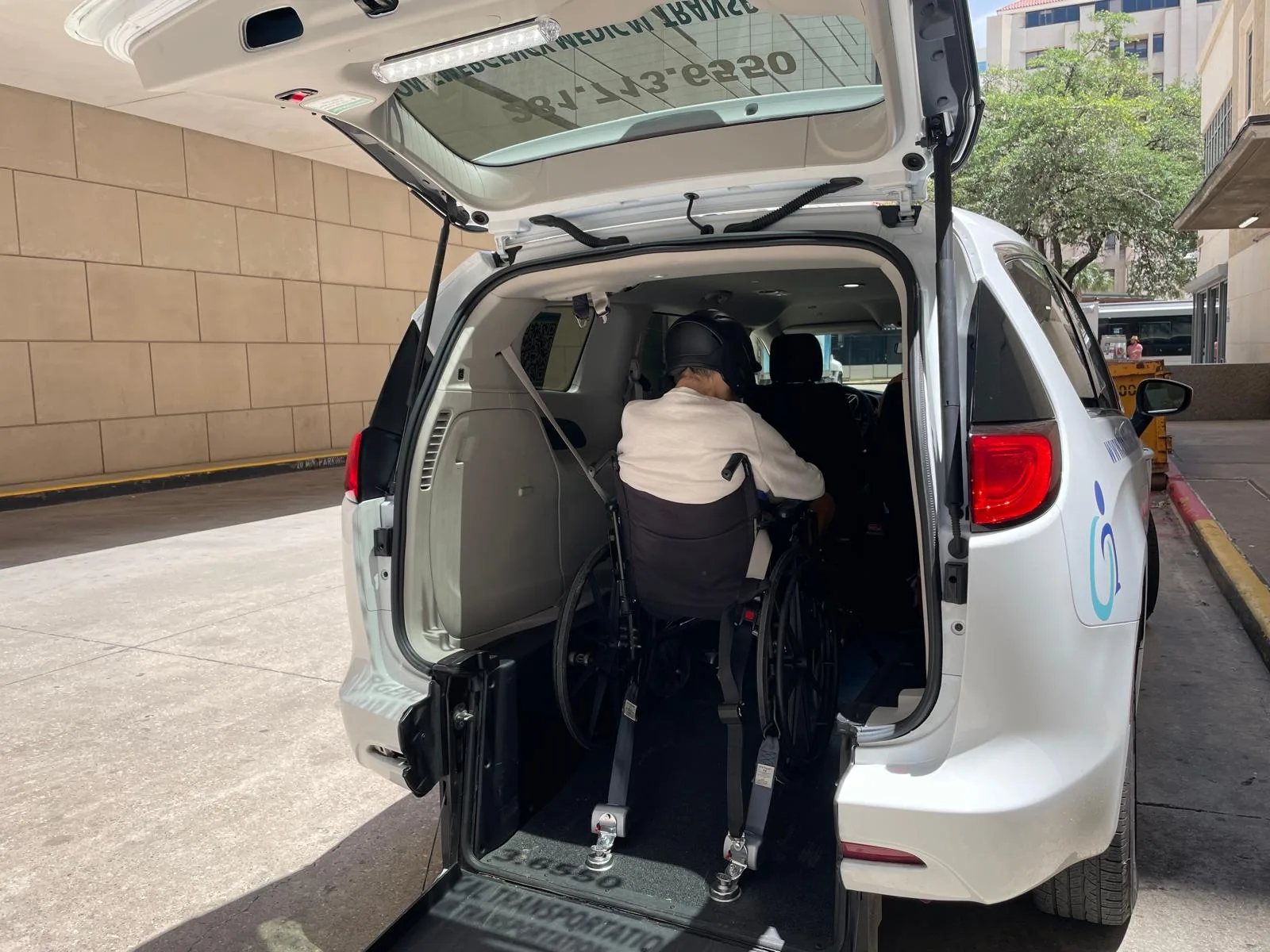 Wheelchair-accessible van with rear ramp and a passenger boarding